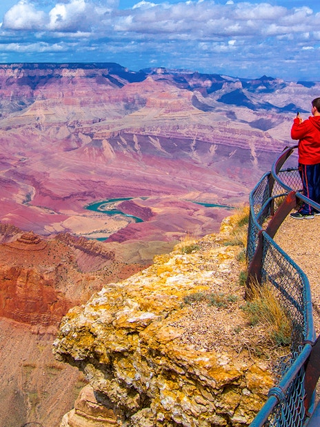 Visitors at Grand Canyon South Rim overlook vast canyon landscape.