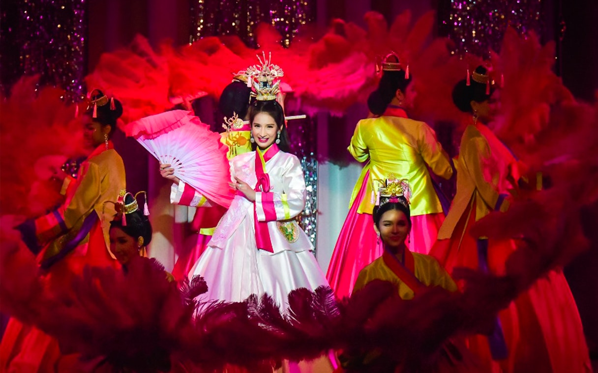 Performers in traditional costumes at Golden Dome Cabaret Show, holding pink fans.