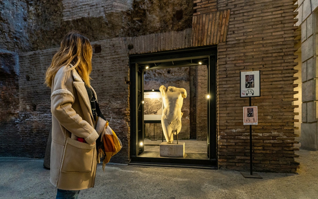 Visitor exploring ancient statue in Rome's Navona Square and Trevi District Underground.