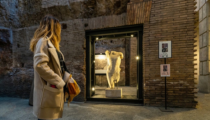 Visitor exploring ancient statue in Rome's Navona Square and Trevi District Underground.