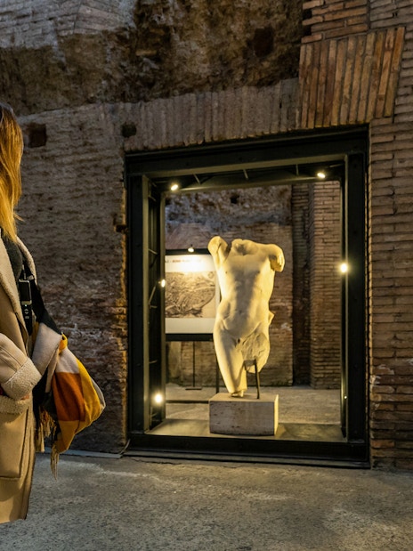 Visitor exploring ancient statue in Rome's Navona Square and Trevi District Underground.