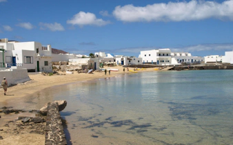 Coastal village of Caleta de Sebo with white buildings and beach on La Graciosa, Canary Islands, Spain.