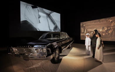 Classic car exhibit with visitors at Zayed National Museum, Abu Dhabi.