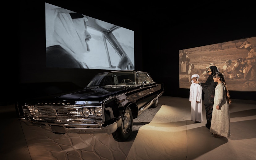 Classic car exhibit with visitors at Zayed National Museum, Abu Dhabi.