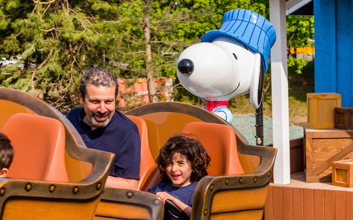 Father and child enjoying SNOOPY'S® Racing Railway ride at Canada's Wonderland.