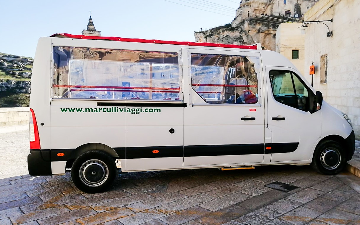 Tour bus in Matera for audio-guided Casa Grotta visit.