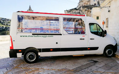 Tour bus in Matera for audio-guided Casa Grotta visit.