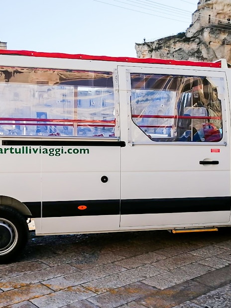 Tour bus in Matera for audio-guided Casa Grotta visit.