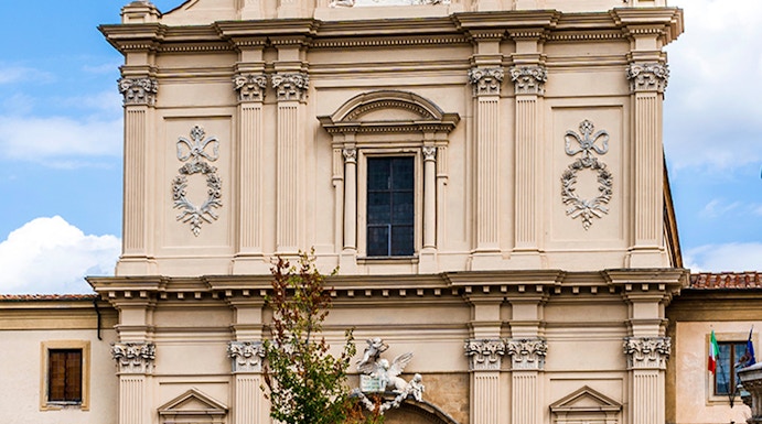 Facade of San Marco Church in Florence, Italy, with detailed sculptures and architectural elements.