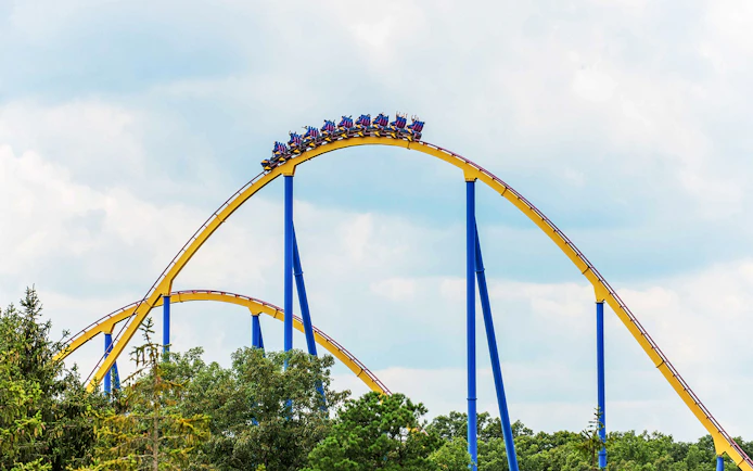 Roller coaster at Six Flags Great Adventure with riders on a steep drop.