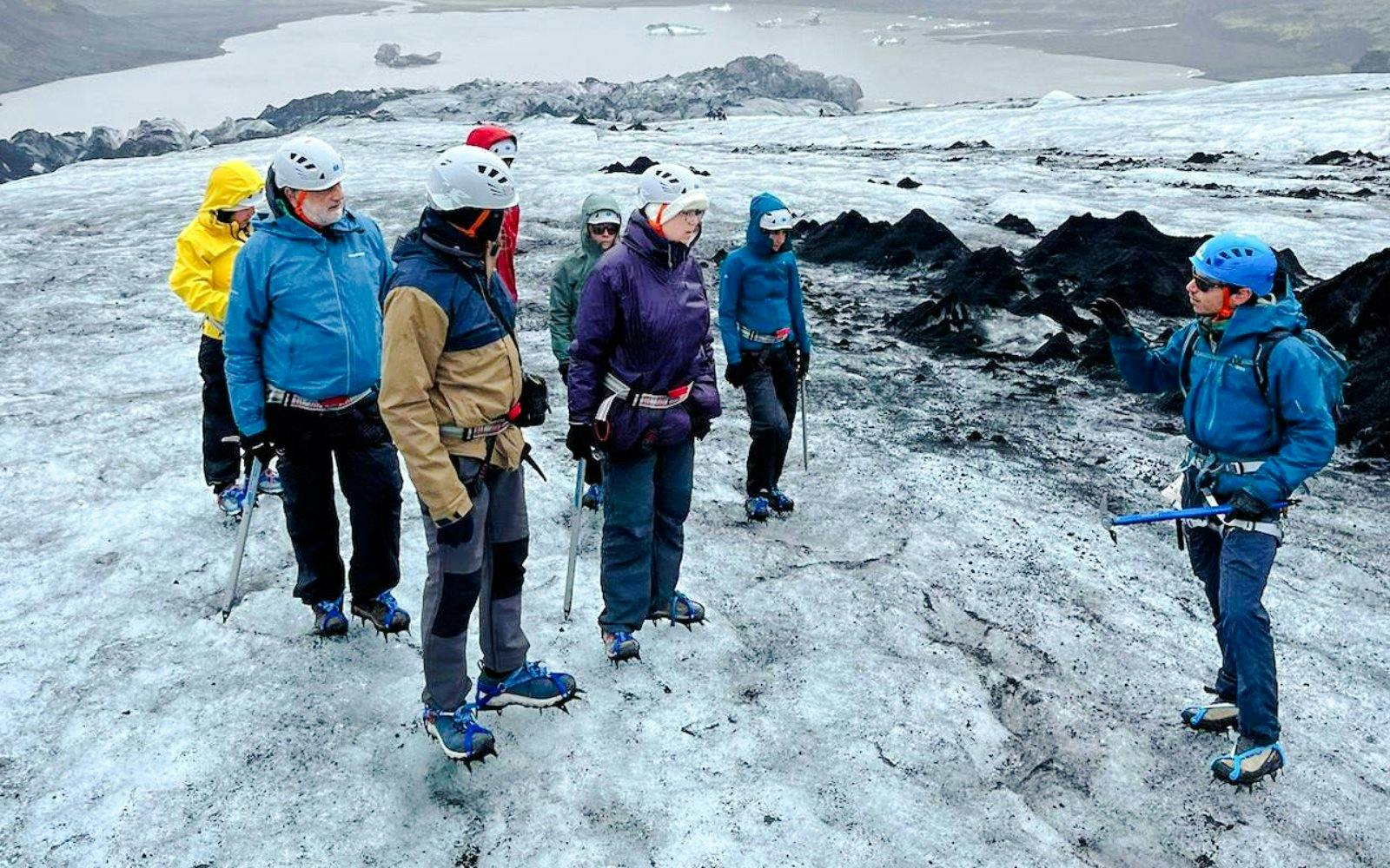 Guests hiking on Sólheimajökull Glacier with a guide during a small group tour in Iceland.