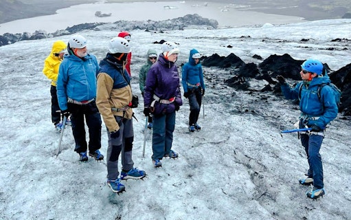 Guests hiking on Sólheimajökull Glacier with a guide during a small group tour in Iceland.
