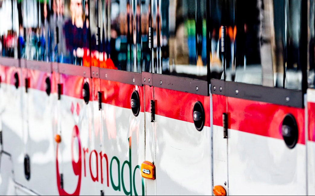 Granada tour bus exterior with logo, part of hop-on hop-off service.