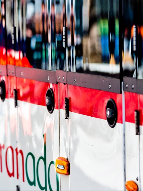 Granada tour bus exterior with logo, part of hop-on hop-off service.