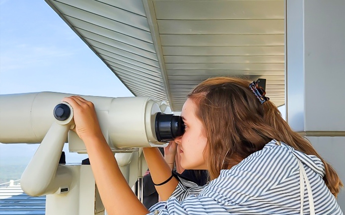 Person using binoculars at Korean Demilitarized Zone observation deck.