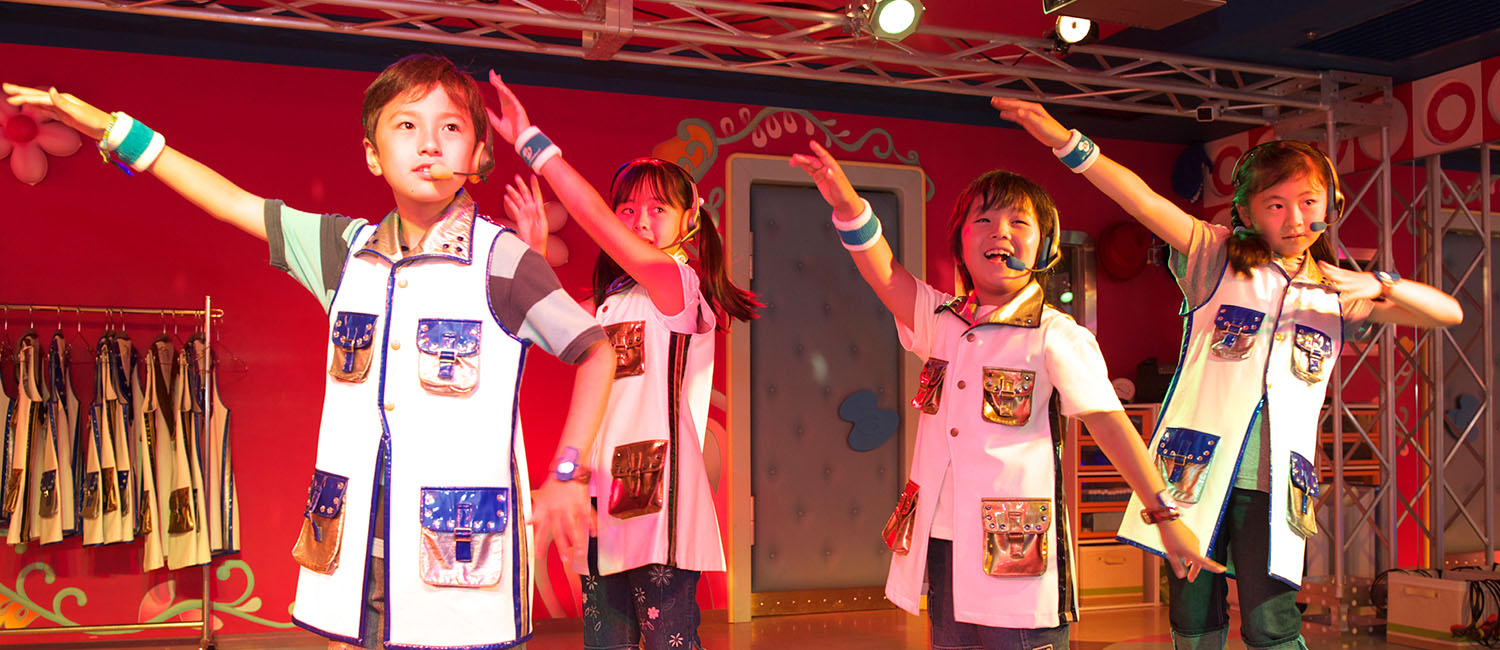 Children performing on stage at KidZania Singapore school program.