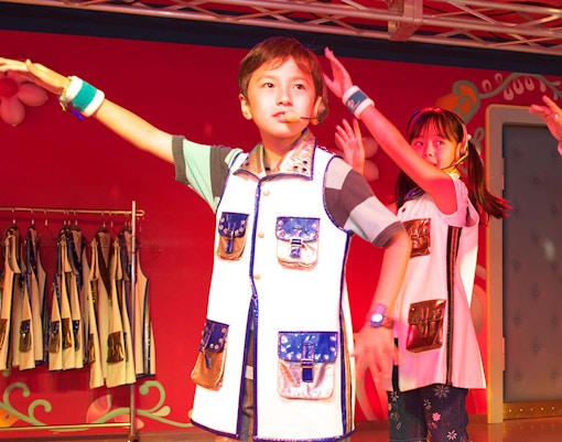 Children performing on stage at KidZania Singapore school program.