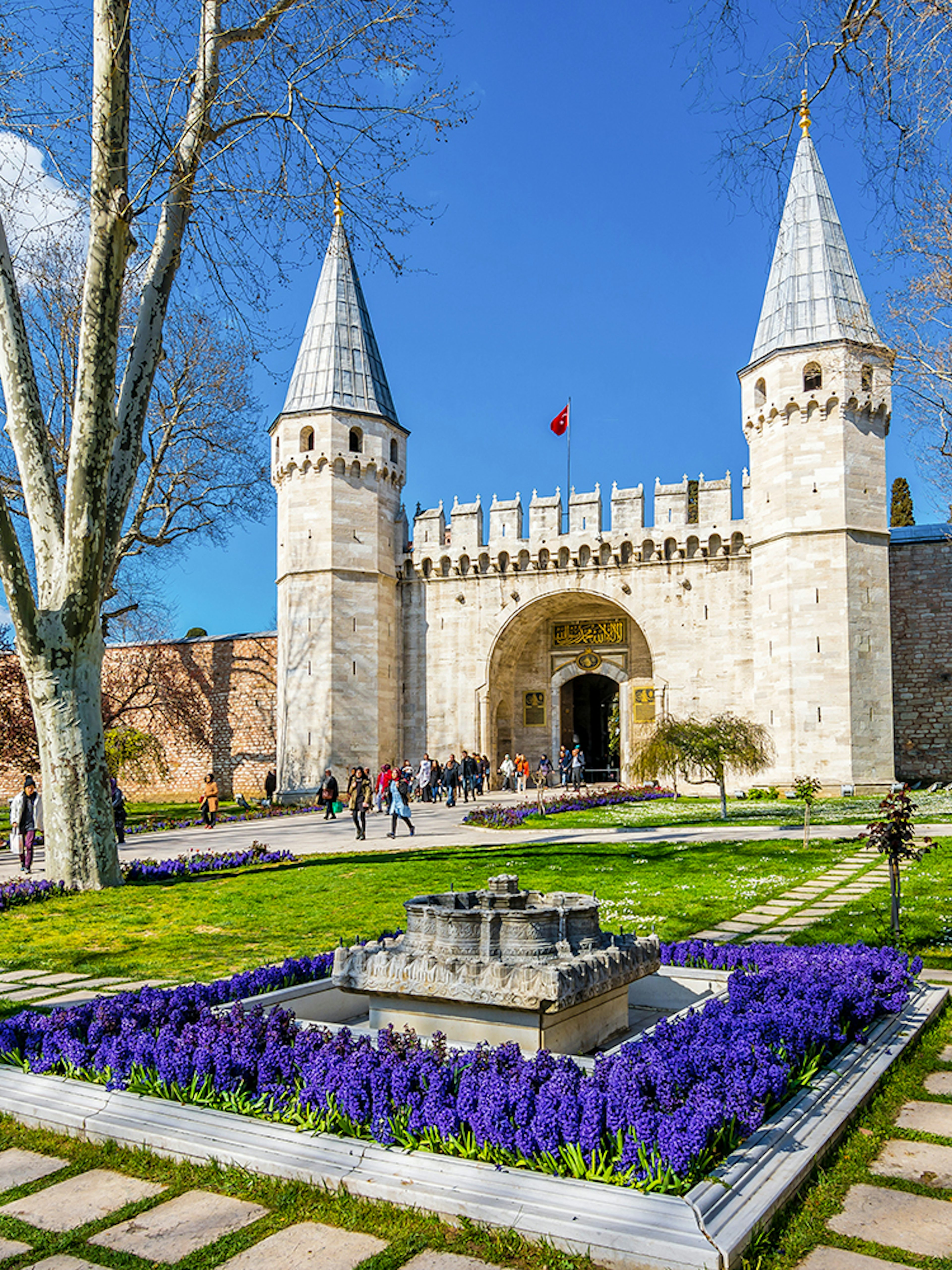Gate of Salutation at Topkapi Palace, Istanbul, with gardens and visitors.
