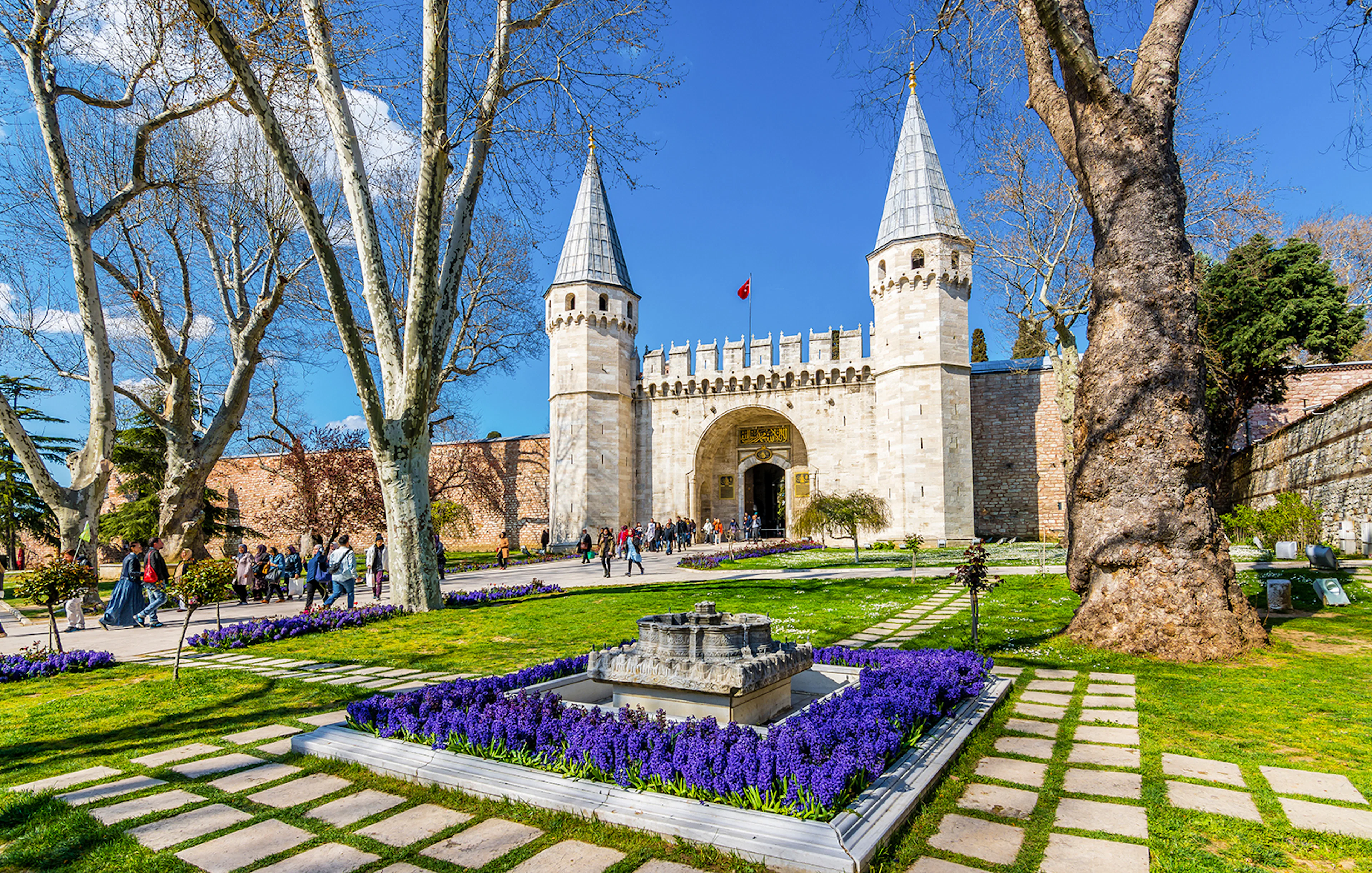 Gate of Salutation at Topkapi Palace, Istanbul, with gardens and visitors.