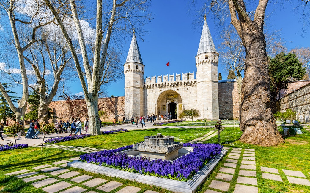 Gate of Salutation at Topkapi Palace, Istanbul, with gardens and visitors.