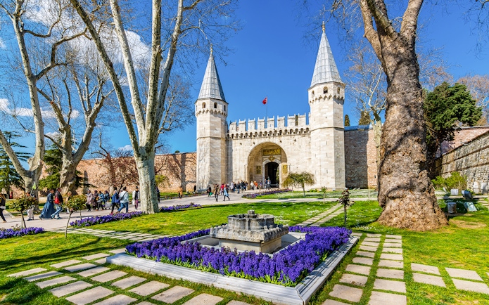 Gate of Salutation at Topkapi Palace, Istanbul, with gardens and visitors.