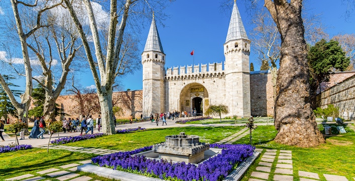 Gate of Salutation at Topkapi Palace, Istanbul, with gardens and visitors.