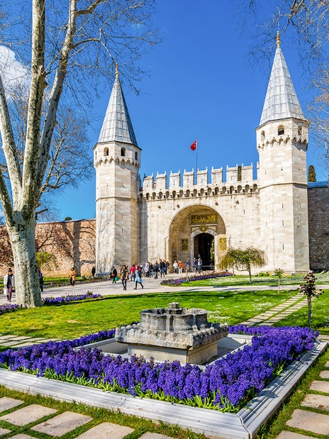 Gate of Salutation at Topkapi Palace, Istanbul, with gardens and visitors.