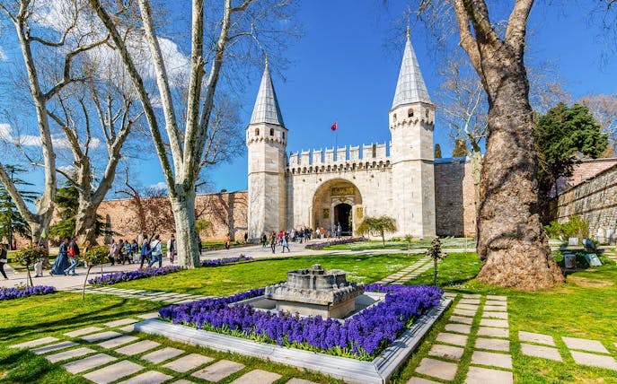 Gate of Salutation at Topkapi Palace, Istanbul, with gardens and visitors.