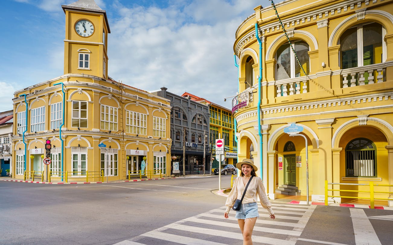 Traveler walking in front of Sino-Portuguese buildings in Phuket Old Town, Thailand.