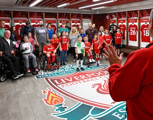 Liverpool FC Legends Q&A and Stadium Tour group in team dressing room.