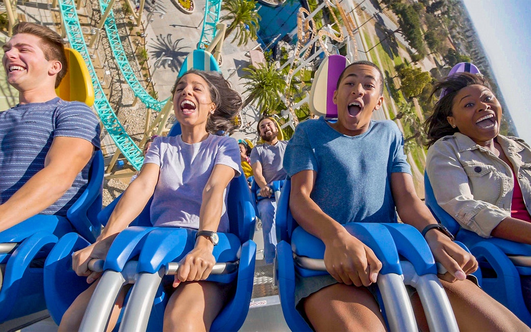 People enjoying a roller coaster ride at an amusement park in Los Angeles.