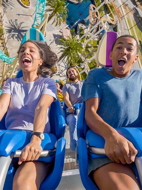 People enjoying a roller coaster ride at an amusement park in Los Angeles.