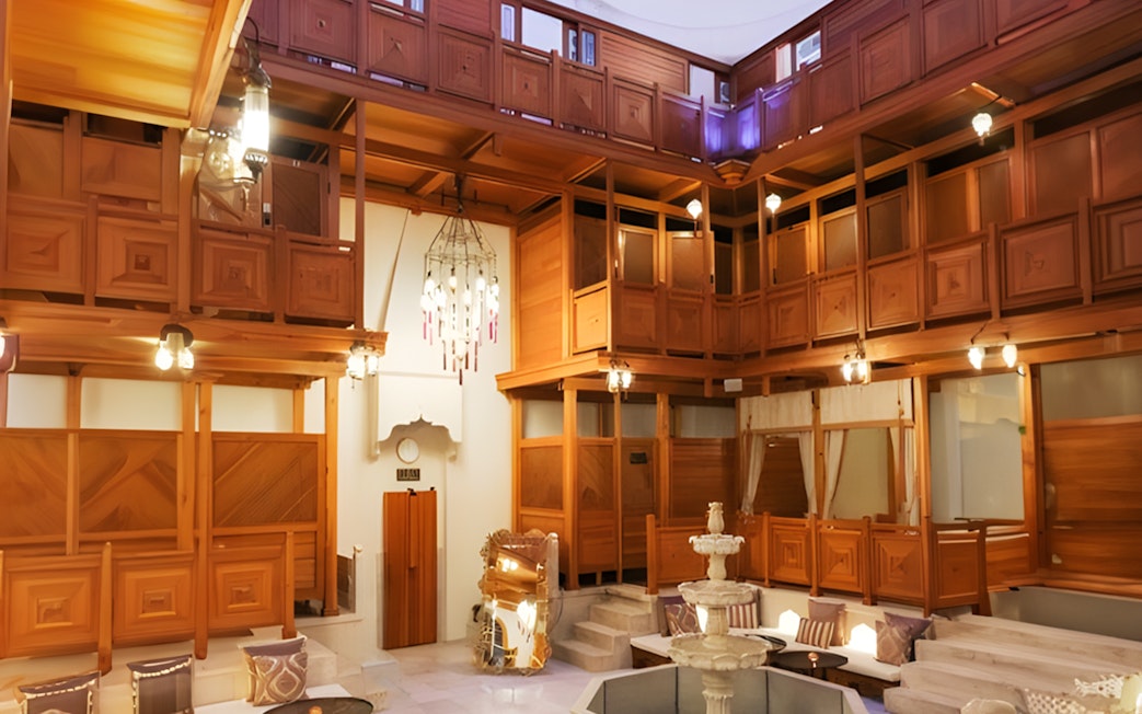 Hurrem Sultan Hamam interior with wooden decor and central fountain in Istanbul.