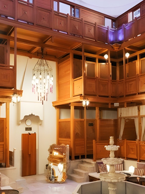 Hurrem Sultan Hamam interior with wooden decor and central fountain in Istanbul.