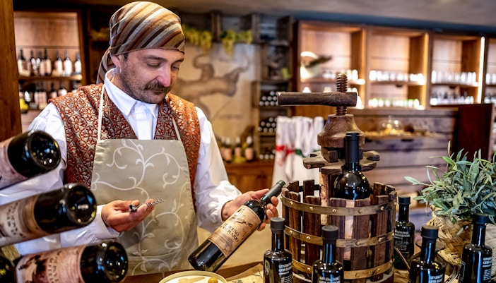 Man holding bottles at Puy du Fou España historical theme park.