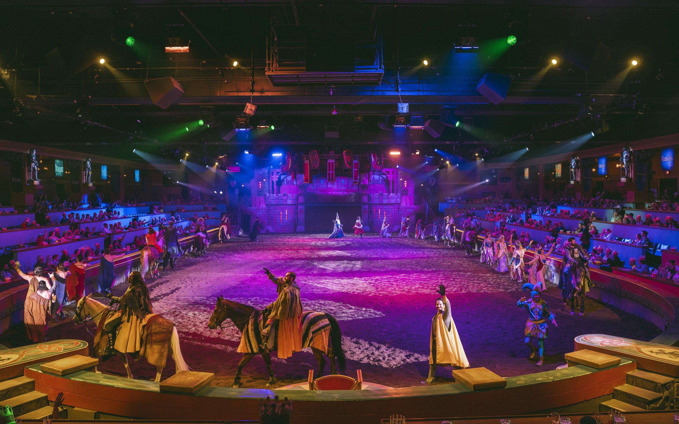 Knights on horseback performing at Tournament of Kings show in Las Vegas arena.