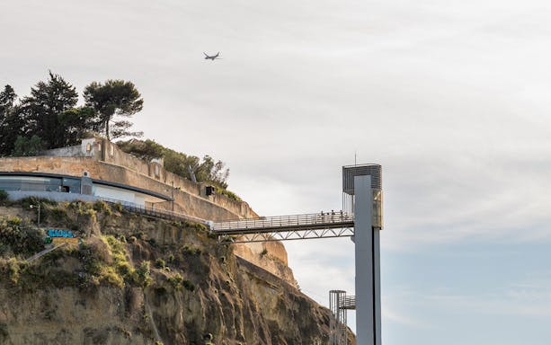 Cliffside view with a modern elevator and walkway near Ribeira do Cavalo Beach, Lisbon.