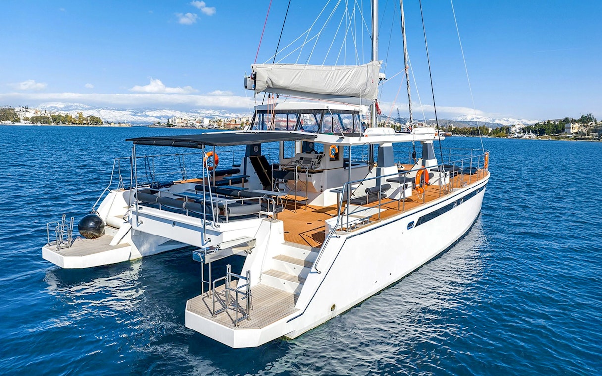Catamaran on Santorini cruise with coastal view in background.