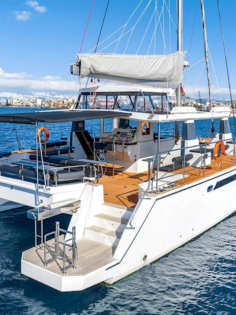Catamaran on Santorini cruise with coastal view in background.