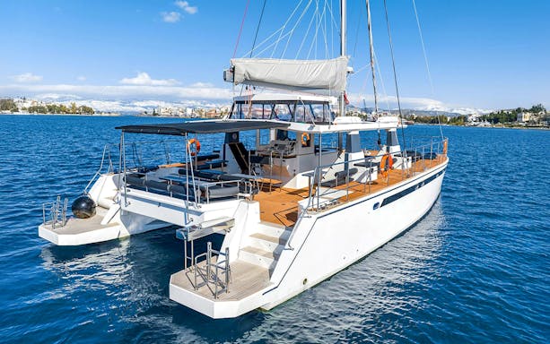 Catamaran on Santorini cruise with coastal view in background.