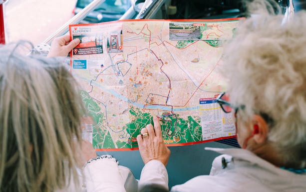 People examining a hop-on hop-off bus map of Turin.
