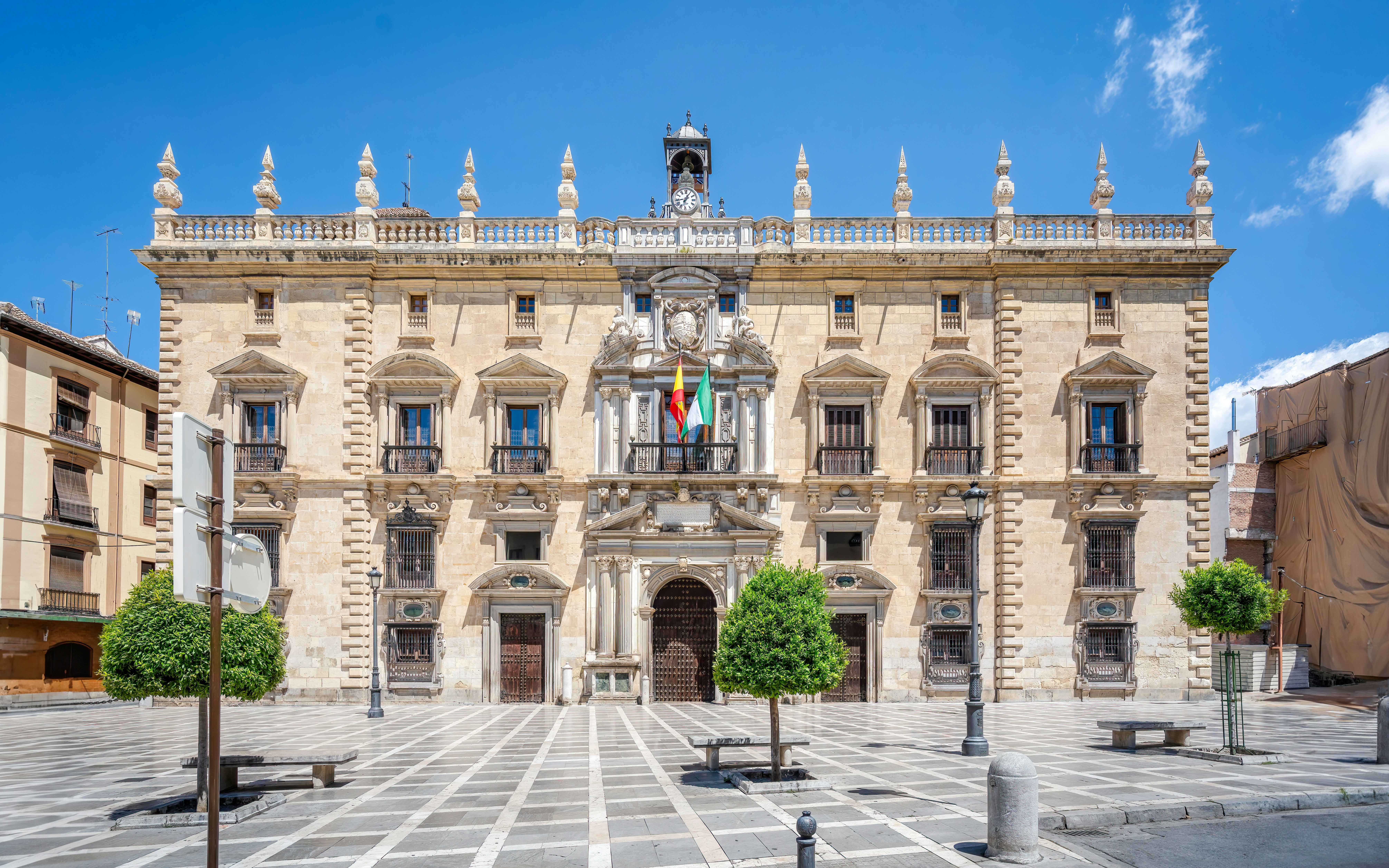 Royal Chancellery Building facade in Granada, Spain, with flags and architectural details.