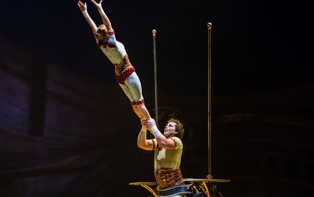 Acrobats performing a balancing act in Cirque du Soleil: Kurios show.