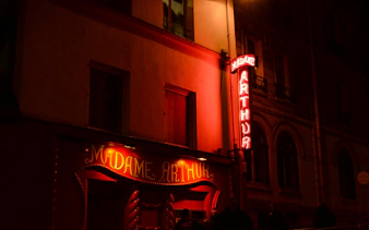 Madame Arthur cabaret entrance with neon lights in Paris.