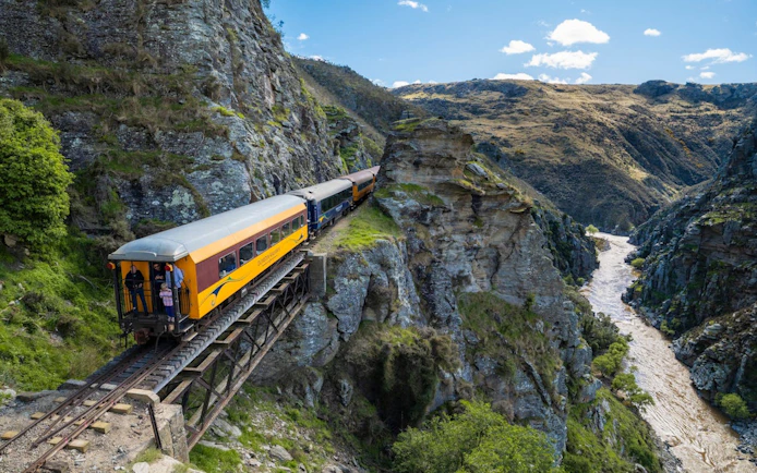 Taieri Gorge train crossing Deep Stream Bridge with scenic canyon views.
