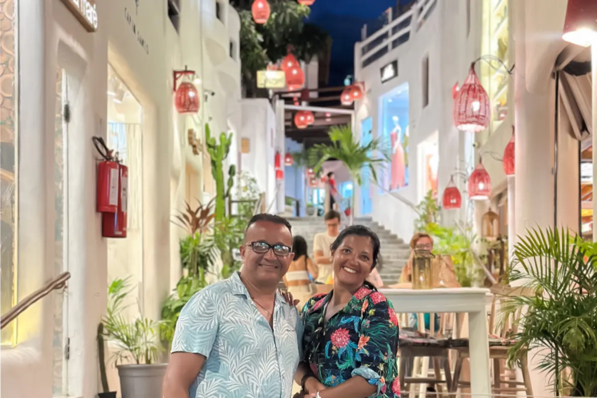 Couple enjoying evening in Pipa Village, Sao Paulo, with vibrant street and lanterns.