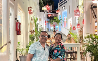 Couple enjoying evening in Pipa Village, Sao Paulo, with vibrant street and lanterns.