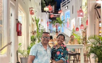 Couple enjoying evening in Pipa Village, Sao Paulo, with vibrant street and lanterns.