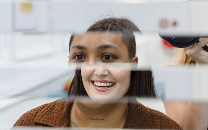 Guest interacting with mirror illusion at Museum of Illusions Amsterdam.
