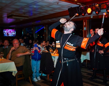 Performer with fire act on Bosphorus dinner cruise with live audience.